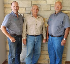 Three men smiling together for a photo